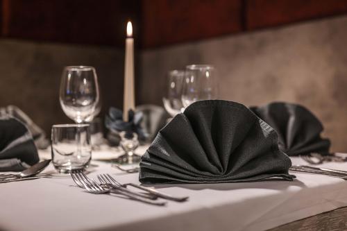 布鲁尼科Hotel Tannenhof的一张桌子,上面有白色的桌布,上面有黑色的餐巾纸
