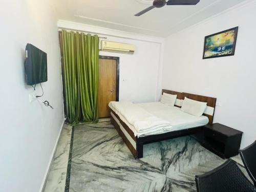 新德里Hotel Saket Place - Near Saket Metro的一间卧室配有床和绿帘