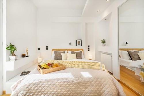雅典OPEN SKIES- PENTHOUSE IN PLAKA- ACROPOLIS VIEW!的一间卧室配有一张床铺,上面有一篮水果