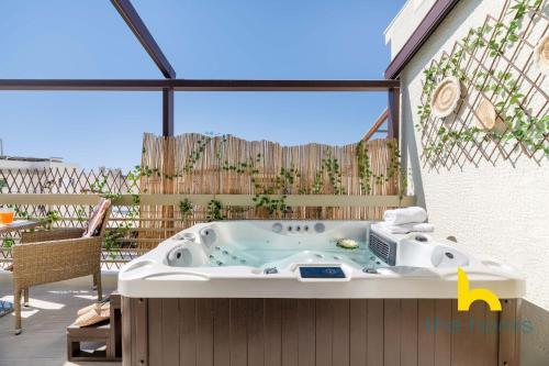 雅典Athenian Sky Retreat: Jacuzzi & Fresh Elegance!的庭院中设有一个按摩浴缸。