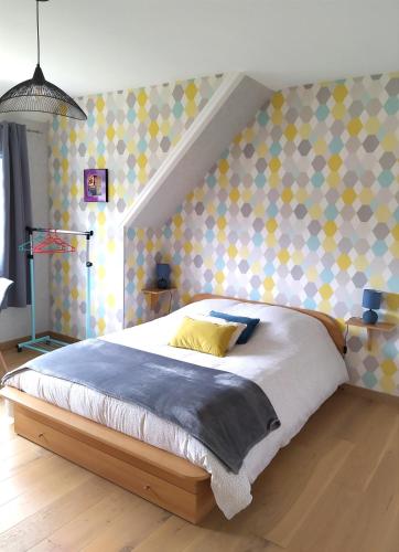 库唐斯La Cotentine的一间卧室配有一张带黄色枕头的大床
