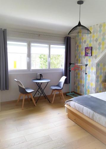 库唐斯La Cotentine的卧室配有一张床和一张桌子及椅子
