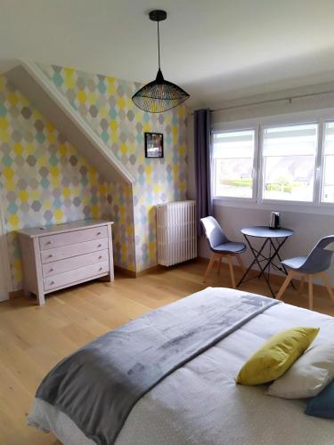 库唐斯La Cotentine的卧室配有一张床和一张桌子及椅子