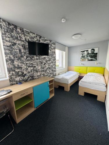 克拉德诺斯勒提斯特体育酒店的客房设有两张床和一台墙上的电视