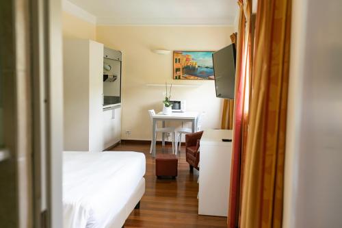 热那亚雷克斯公寓酒店的小房间设有一张床和一张桌子