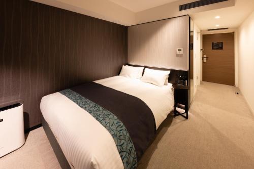 大阪Hotel Vischio Osaka-JR Hotel Group的一间卧室,卧室内配有一张大床