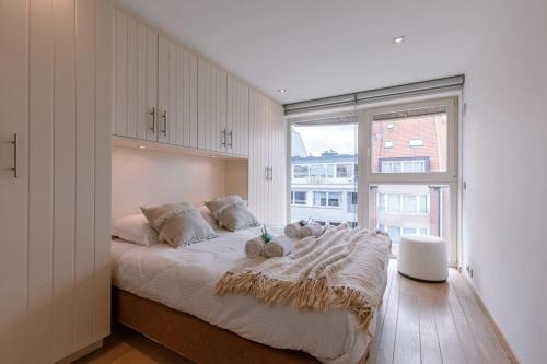 克诺克－海斯特Lovely and spacious apartment on top location in Knokke的一间卧室设有一张大床和大窗户