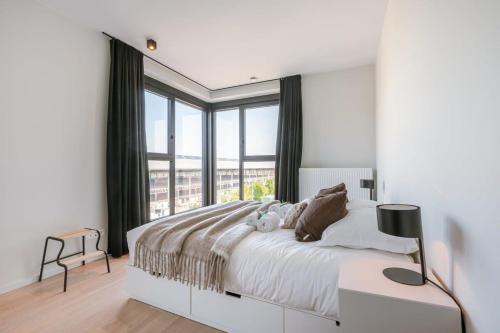 根特Spacious apartment with beautiful terrace near Ghent的一间卧室设有一张大床和大窗户