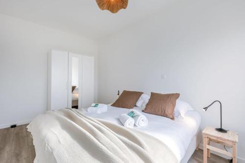 布鲁日Brand new apartment with stunning harbor views的白色卧室,配有带毛巾的床