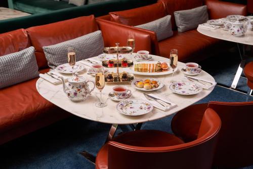 伦敦Bvlgari Hotel London的桌子上放着杯子和盘子