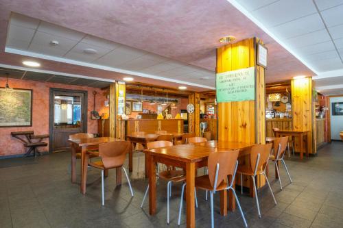 贝纳斯克HOTEL TURPÍ的用餐室配有木桌和椅子