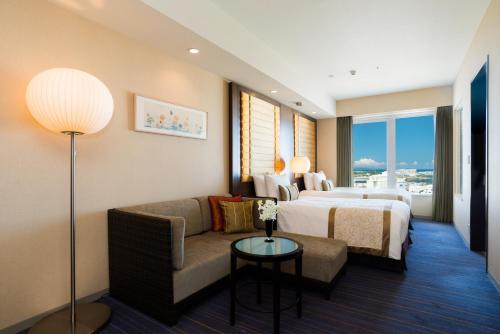 那霸冲绳丽嘉皇家大酒店的酒店客房,配有床和沙发