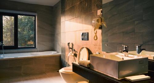 博卡拉Villa Karma Pokhara的浴室配有盥洗盆、卫生间和浴缸。