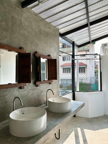 清迈Sleep Owl Chiang Mai的带大窗户的浴室内的2个盥洗盆