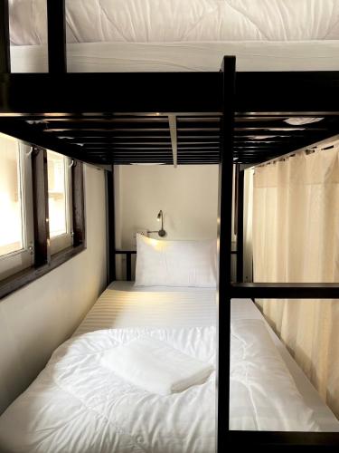 清迈Sleep Owl Chiang Mai的卧室配有2张双层床和白色床单