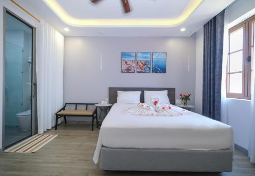 富国BELLA HOTEL PHU QUOC -Sunset Town, Địa Trung Hải- BIG PROMOTION 2024的卧室配有一张白色的大床和一张桌子