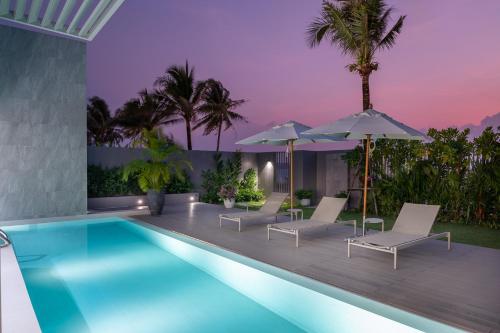 邦涛海滩Beachfront Residences - Stunning Sea and Lake View的一个带躺椅和遮阳伞的游泳池