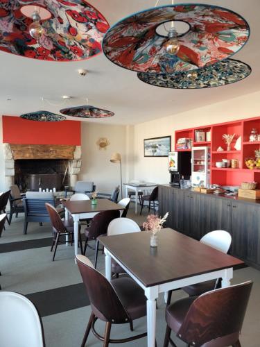 基伯龙波特哈利甘酒店的一间带桌椅和壁炉的餐厅