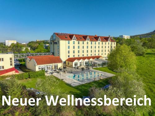 耶拿FAIR RESORT All Inclusive Wellness & Spa Hotel Jena的享有带游泳池的建筑的空中景致