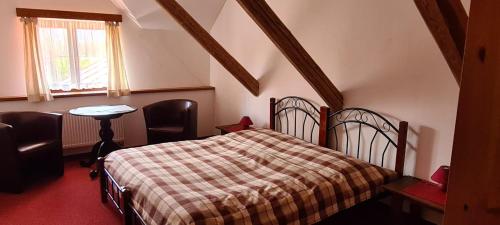 克拉利基Rezidence Lipka的一间卧室配有一张床、一张桌子和一个窗户。