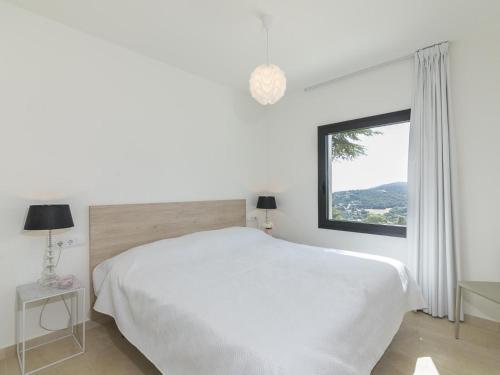 卡隆赫VILLA LA DOLÇA CALONGE的白色的卧室设有一张大床和一个窗户