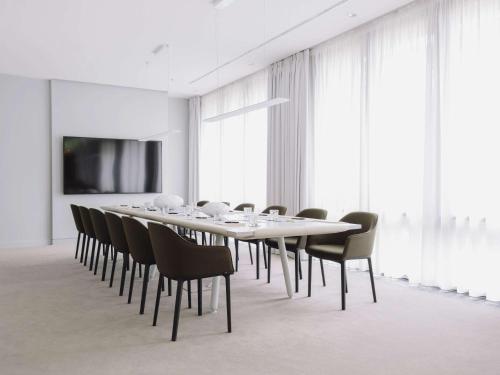 柏林铂尔曼柏林施维泽霍夫酒店的一间会议室,配有长桌子和椅子
