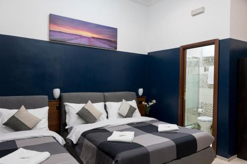 罗马STELLA GUEST HOUSE O AFFITTACAMERE的一间卧室设有两张床和蓝色的墙壁
