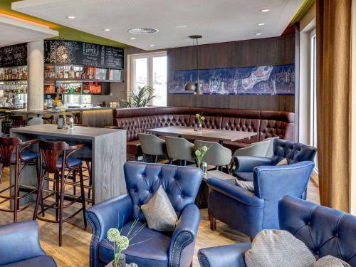 蒂宾根ibis Styles Tuebingen的一间设有蓝色桌椅的餐厅和一间酒吧