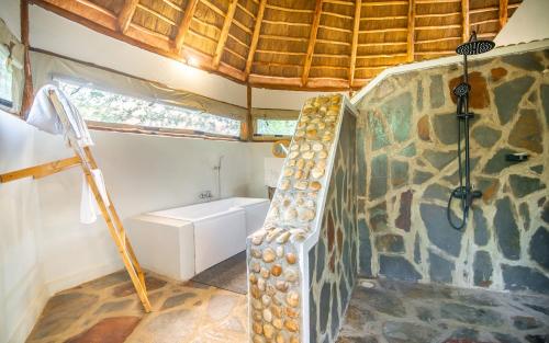 KatokeEmbogo Safari Lodges的一间设有长颈鹿墙的客房里设有楼梯的浴室