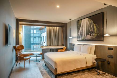 都柏林Radisson Blu Royal Hotel Dublin的酒店客房设有一张大床和一张书桌。