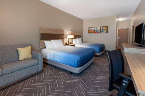 米德尔敦La Quinta Inn & Suites by Wyndham Middletown的酒店客房,设有两张床和一张沙发
