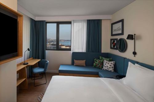 伊斯坦布尔Hampton By Hilton Istanbul Sirkeci的酒店客房,配有床和沙发