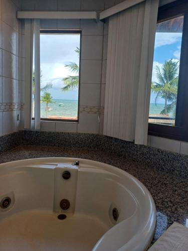 圣若泽-达科罗阿格兰迪Pousada Vivenda Oriente的带浴缸的浴室,享有海滩美景