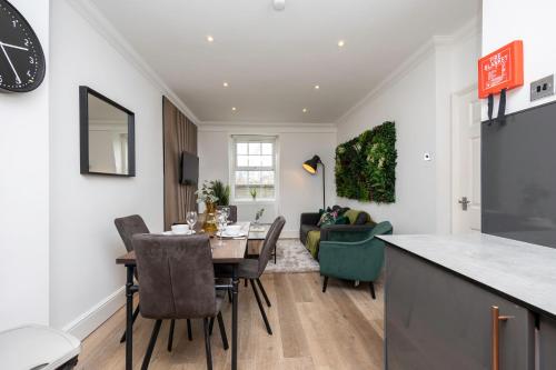 布莱顿霍夫Stunning Two Bedroom Brighton Penthouse的厨房以及带桌椅的起居室。
