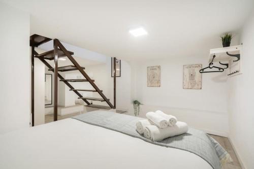 马德里Charming flat in Madrid-Rio的白色卧室,配有梯子和床上的毛巾