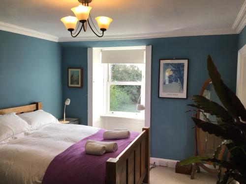 洛克比Mansefield Rooms的一间卧室配有一张蓝色墙壁的床和一扇窗户