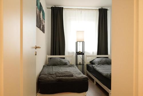 杜伊斯堡Möblierte 3-Zimmer-Wohnung nahe Düsseldorf in Duisburg-Süd的一间卧室设有两张床和窗户。
