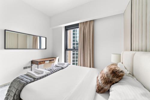 迪拜Luxury 2 Bedroom Apartment - Next to Dubai Opera的白色的卧室设有一张大床和一个窗户