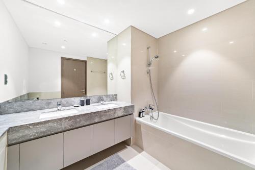 迪拜Luxury 2 Bedroom Apartment - Next to Dubai Opera的带浴缸、水槽和淋浴的浴室