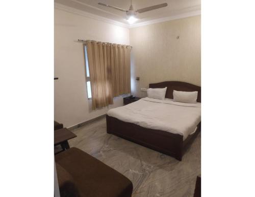 博帕尔Hotel Vishnu Villas, Bhopal的一间卧室设有一张床和一个窗口