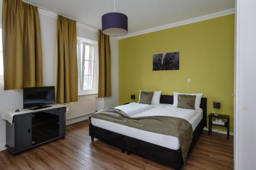 贝尔多夫小径旅馆自然及运动酒店的一间卧室配有一张床和一台平面电视