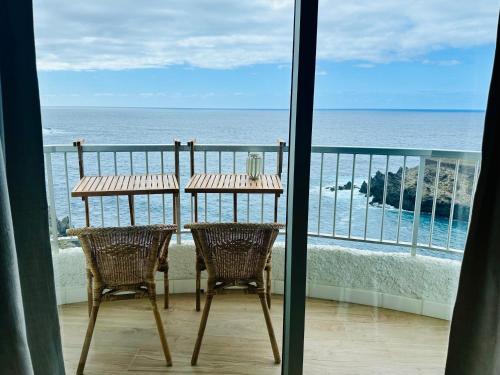 伊科德洛斯维诺斯Apartment Blue Monis with Amazing Views的俯瞰大海的阳台配有桌椅