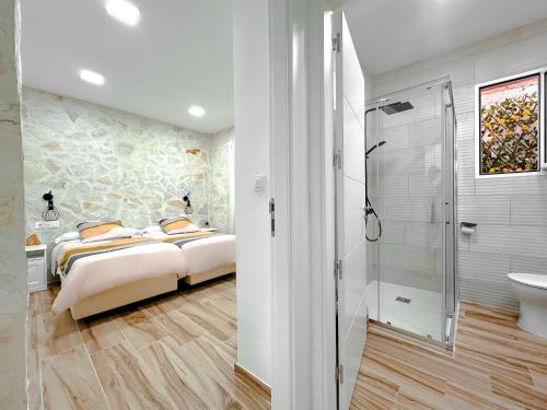 El CuervoEl Hortal i lloo的一间卧室设有两张床和一个步入式淋浴间。