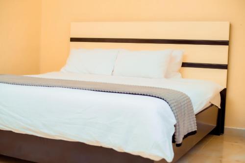 布兰太尔Hillside Luxury Lodge的一间卧室配有带白色床单和枕头的床。