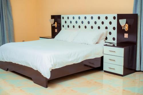 布兰太尔Hillside Luxury Lodge的一间卧室配有一张大床和一个床头柜