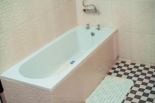 布兰太尔Hillside Luxury Lodge的浴室铺有瓷砖地板,配有白色浴缸。