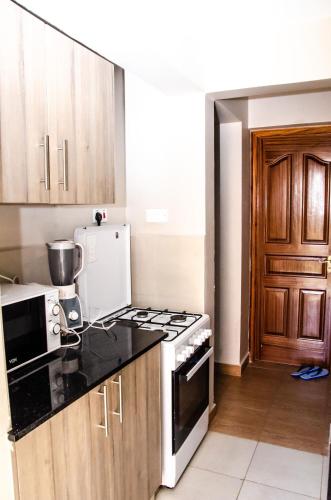 ThikaKeisha Homes的厨房配有炉灶和冰箱。