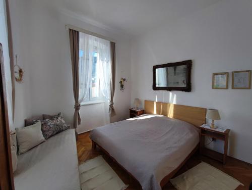 科米扎APARTMAN RIVA 2的一间卧室设有床、窗户和沙发