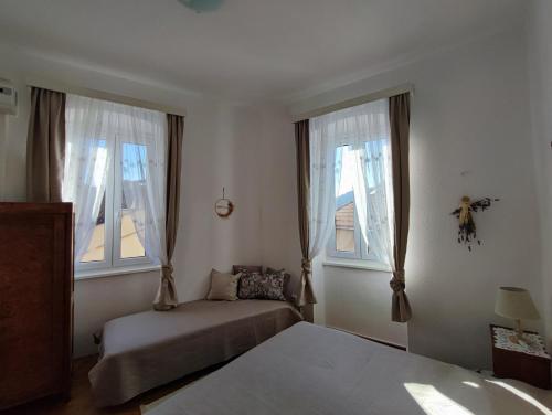 科米扎APARTMAN RIVA 2的一间卧室设有一张床和两个窗户。