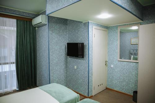 巴库Address Boutique Hotel Baku的卧室配有一张床,墙上配有电视。